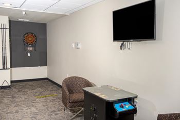 Darts, Pacman game, and mounted TV in the community room.
